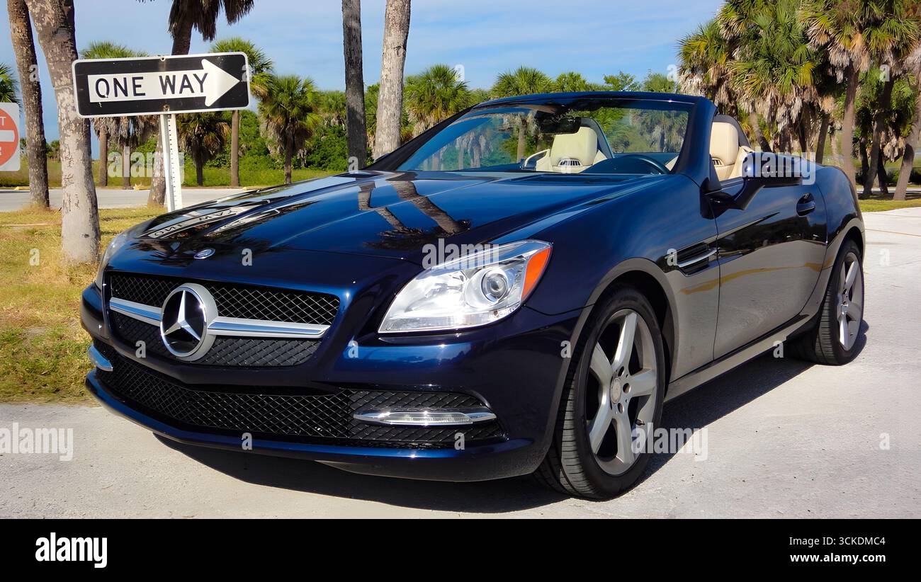 Lussuosa Mercedes-Benz SLK blu decappottabile parcheggiata vicino a palme in una giornata di sole in Florida, Stati Uniti. Foto Stock