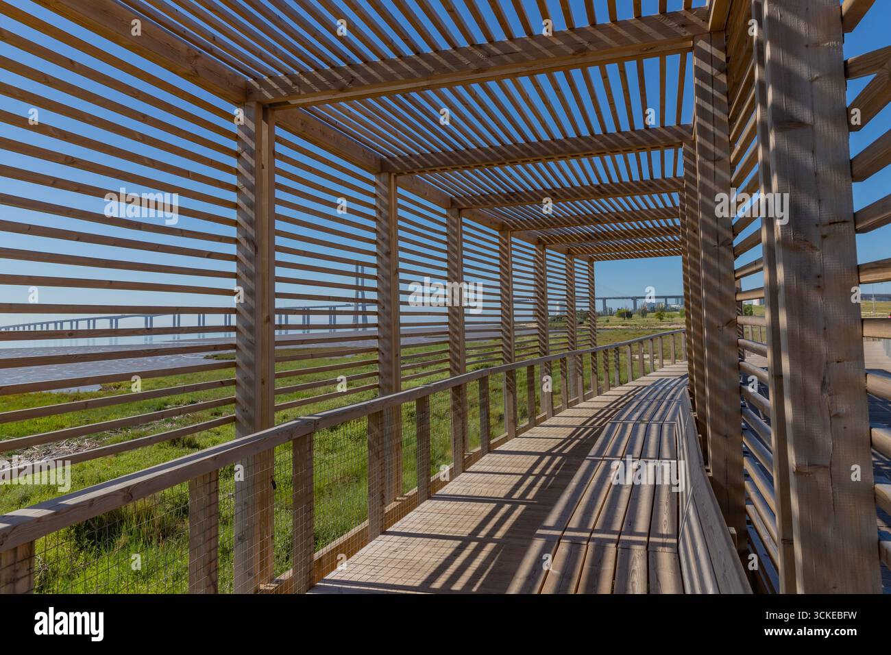 Passerella in legno a Loures, vicino a Lisbona e al Parque das Nacoes, con vista sul ponte Vasco da Gama e sul fiume Tago. Foto Stock