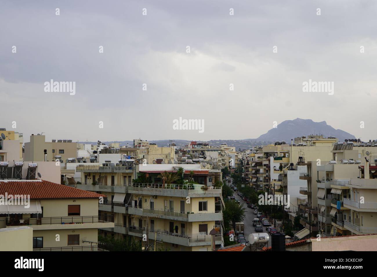 Una vista elevata del fitto paesaggio urbano di Heraklion con una montagna in un giorno coperto, che offre uno sguardo sulla vita della città dell'isola. Foto Stock