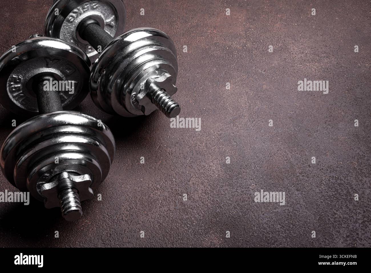 Manubri pesanti su sfondo scuro, spazio di copia. Modello di concetto di sport, fitness e stile di vita sano. Foto Stock