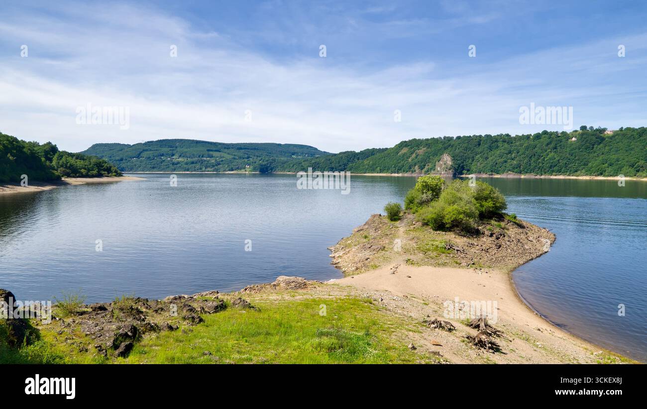 Piccola penisola nel bacino idrico di Bort-Les-Orgues in Francia sotto un cielo parzialmente nuvoloso Foto Stock