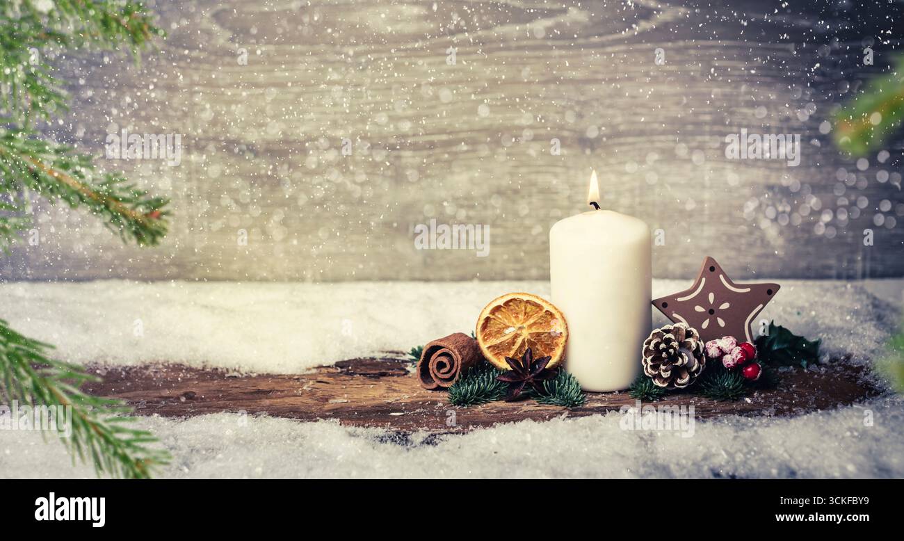 Decorazione dell'avvento con candele accese, corteccia, limone essiccato, coni di pino, rami di abete, bowla, e star alla nevicata, componendo Foto Stock