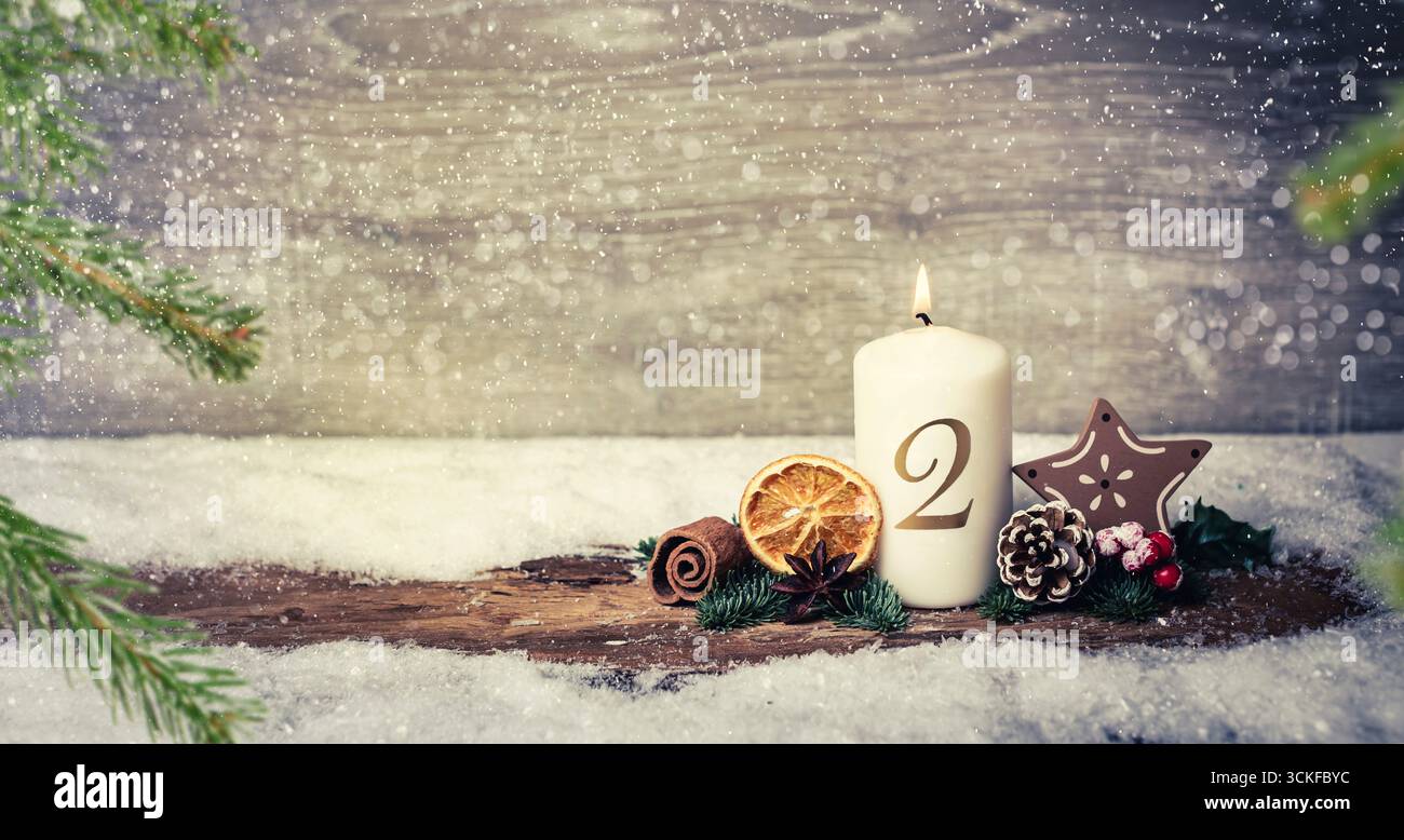 Decorazione dell'avvento con candele accese, corteccia, limone essiccato, coni di pino, rami di abete, bowla, e stella alla nevicata, 2° Avvento, composizione Foto Stock