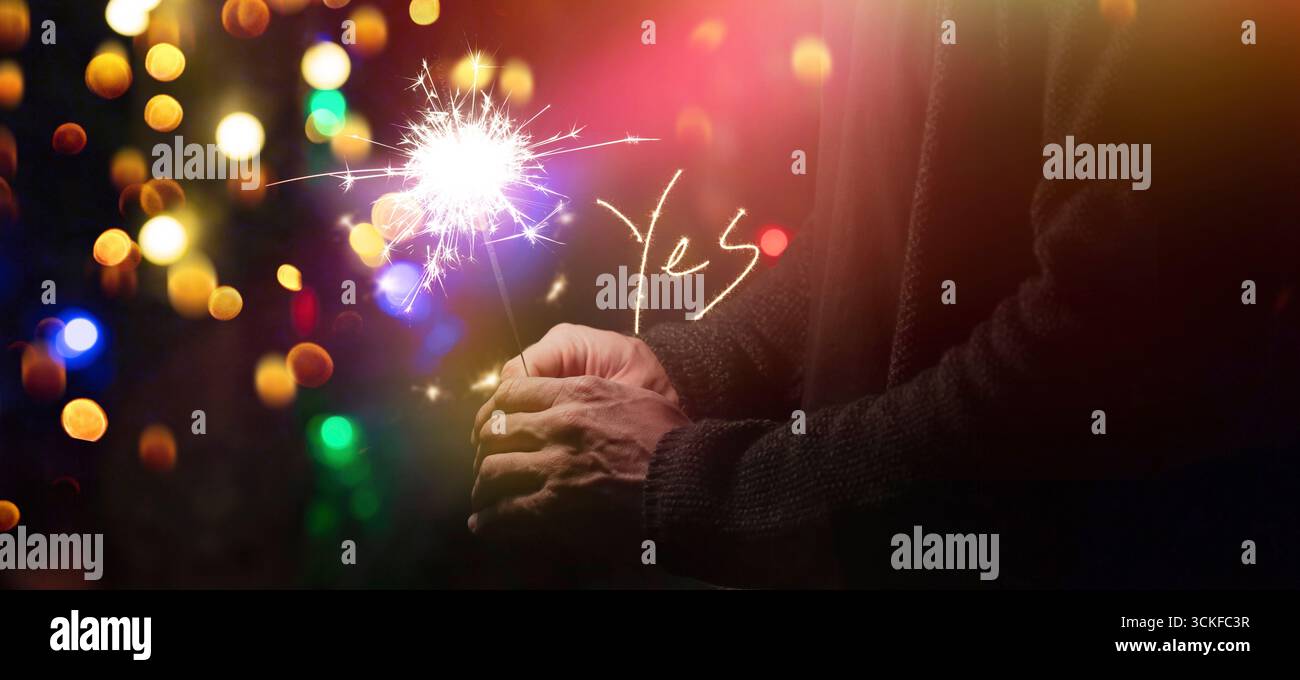 sparkler e “Sì” scrittura leggera nella notte Foto Stock