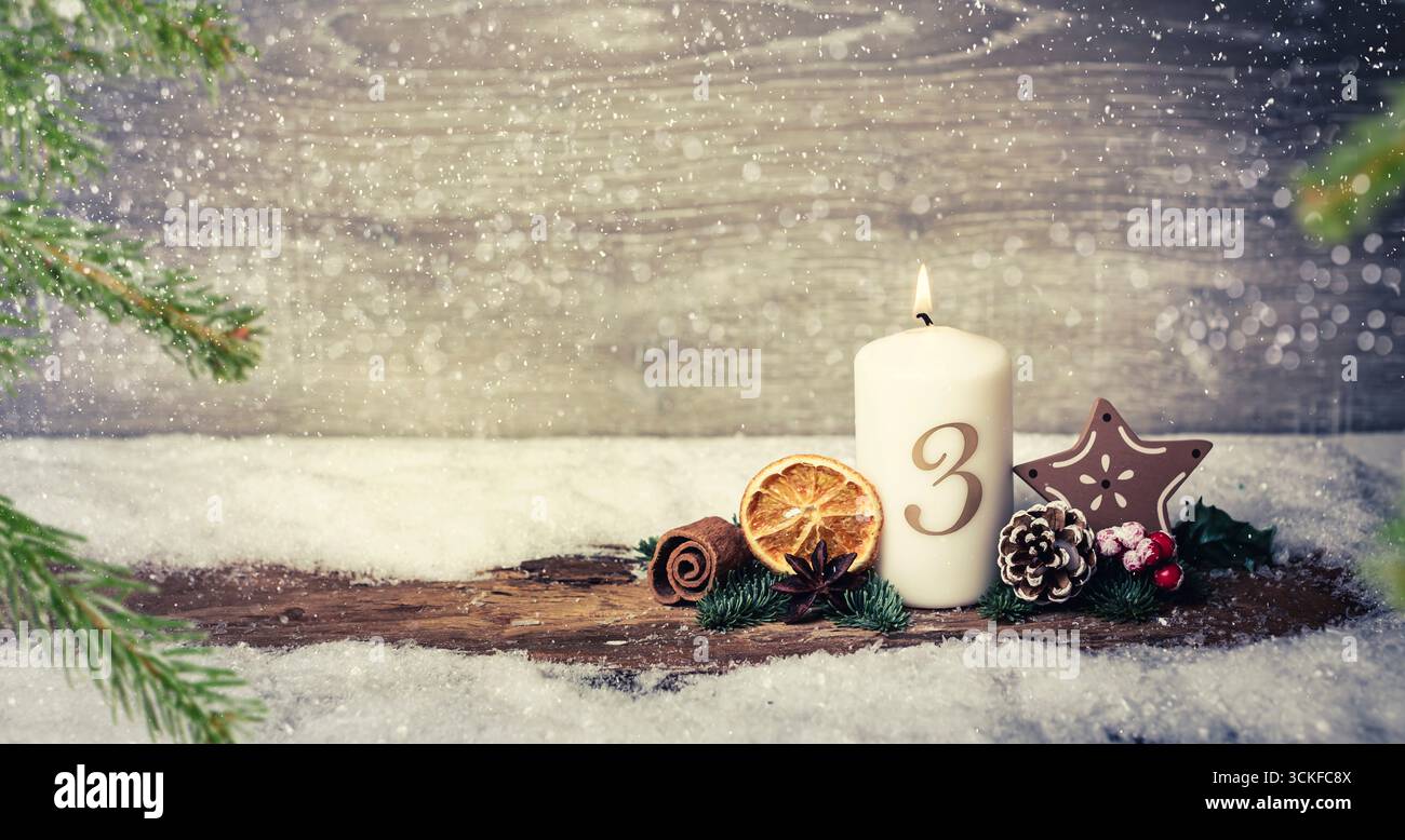 Decorazione dell'avvento con candele accese, corteccia, limone essiccato, coni di pino, rami di abete, bowla, e stella alla nevicata, 3° Avvento, composizione Foto Stock