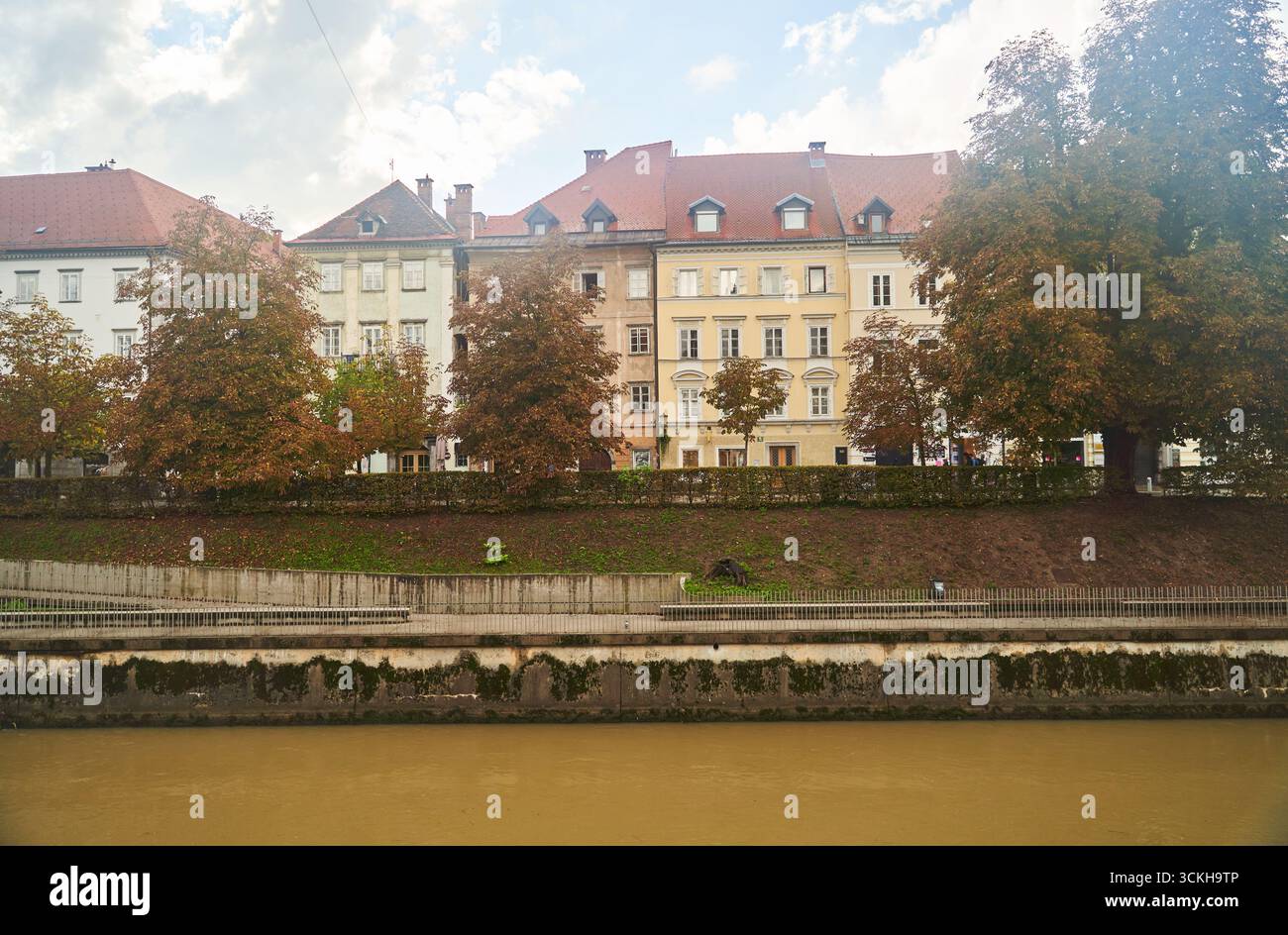 Slovenia, Lubiana - 23 settembre 2022: Una splendida scena autunnale sulle rive del fiume con edifici storici tra lo splendore delle creature naturali Foto Stock