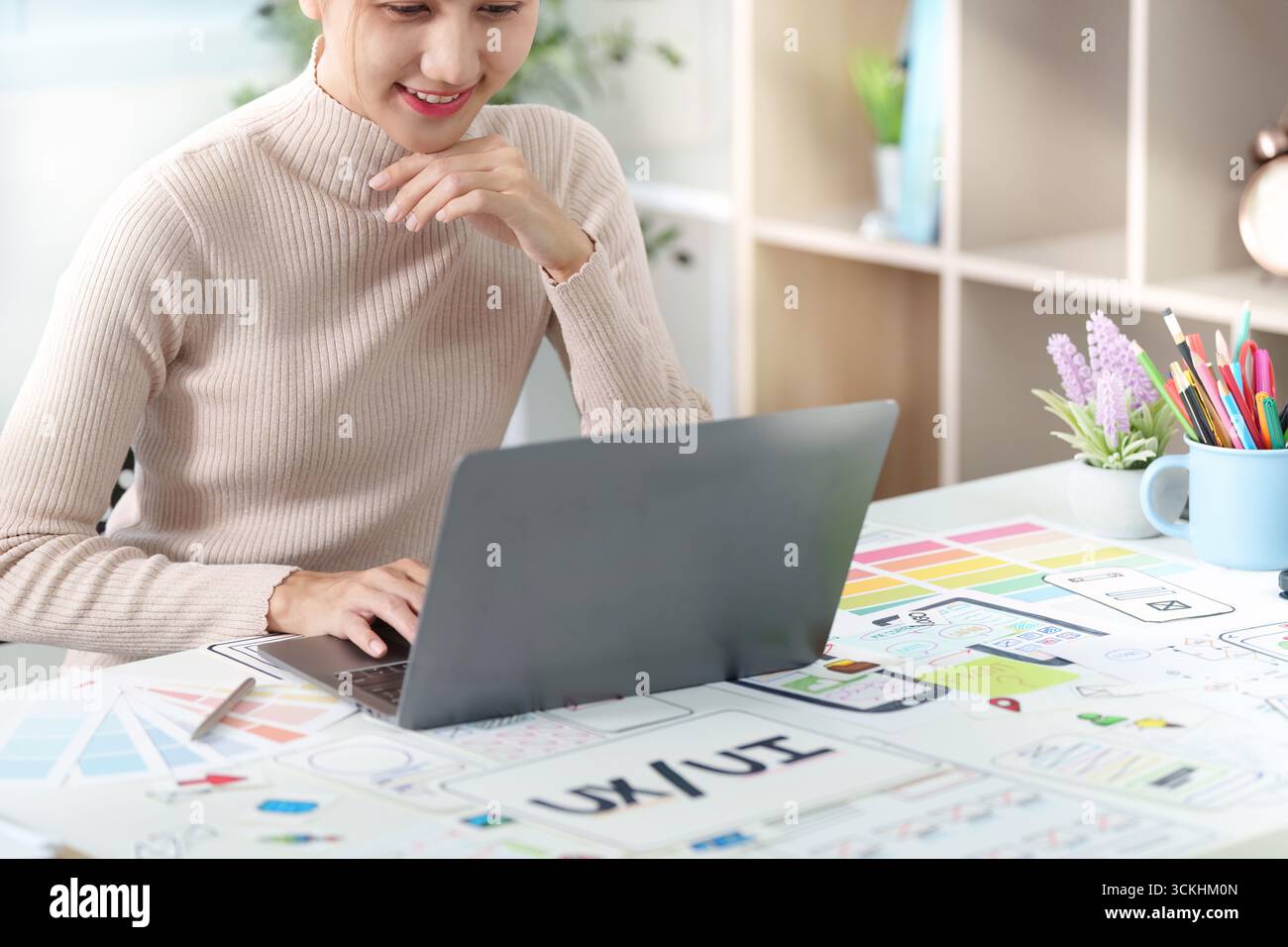 Progettista UXUI impegnato in Digital Project. Professionisti concentrati che lavorano su notebook in un ambiente creativo. Foto Stock