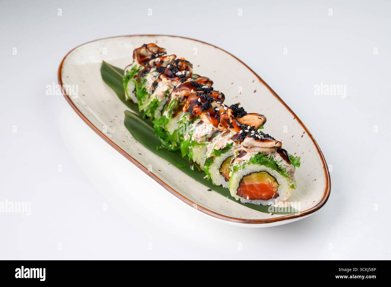Delizioso sushi roll giapponese fusion con salmone, cozze, alghe chuka, ravanelli sottaceto, uova di pesce volanti, e con noci di sesamo e teriyaki Foto Stock