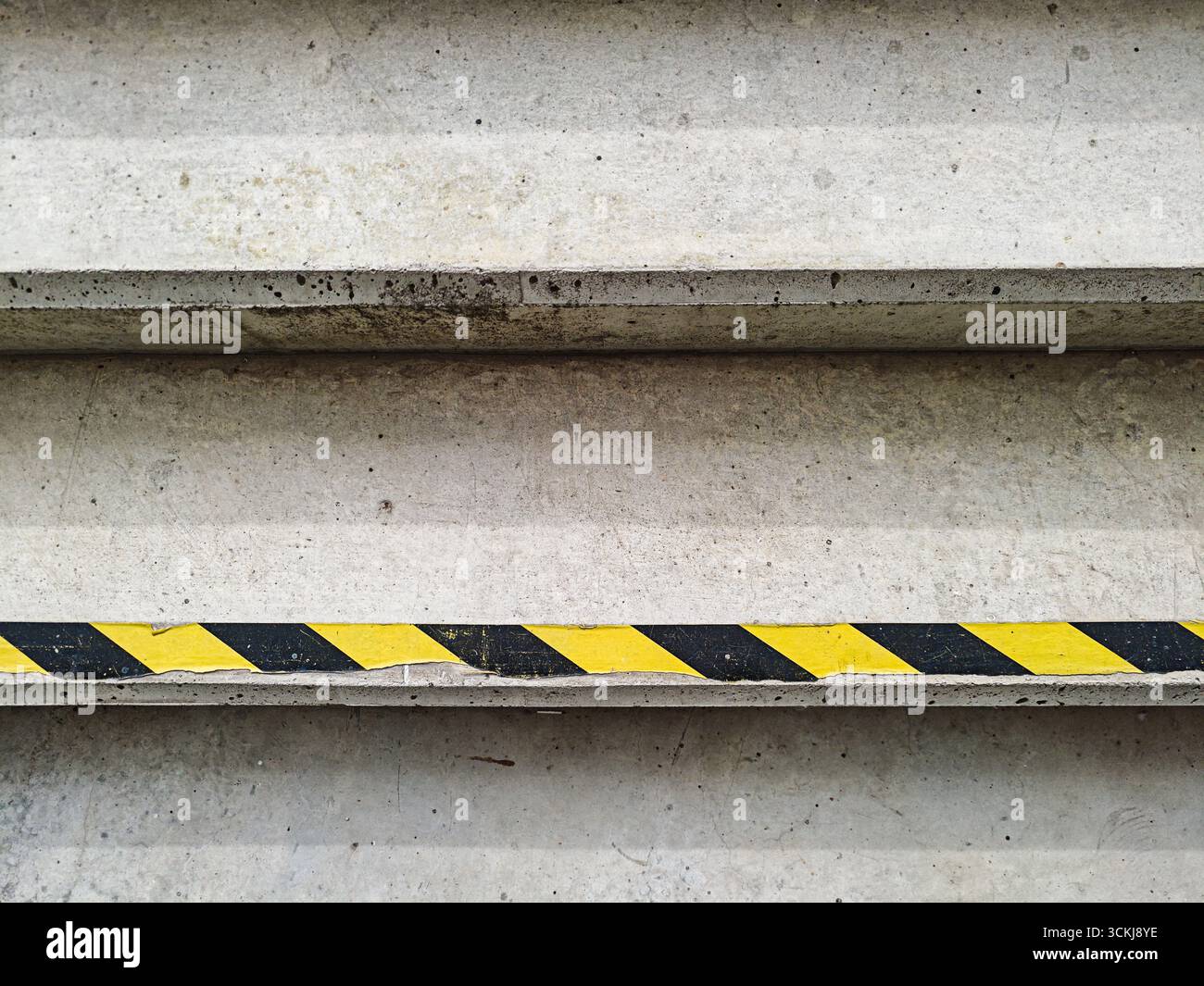 Scale in calcestruzzo con nastro di segnalazione diagonale giallo e nero . Foto di alta qualità Foto Stock