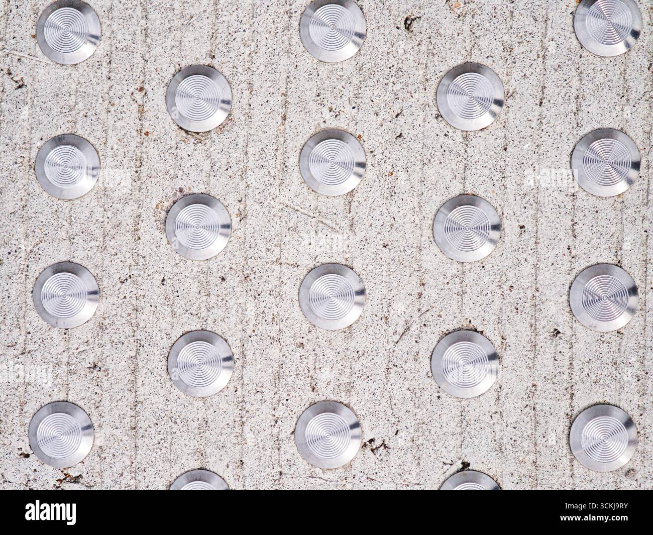 Primo piano di pavimentazione tattile con perni metallici su superfici in calcestruzzo per una guida cieca . Foto di alta qualità Foto Stock