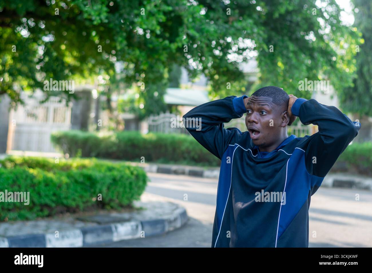Giovane africano che tocca la testa con un'espressione confusa e preoccupata, isolata su sfondo bianco. Concetto di sollecitazione, risoluzione dei problemi e diff Foto Stock