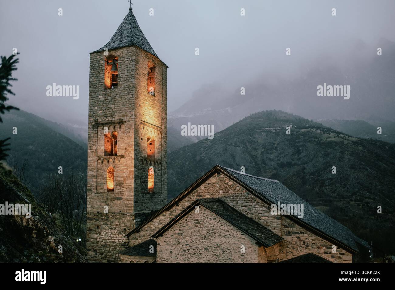 Campanile romanico illuminato nei Pirenei a Dusk Foto Stock