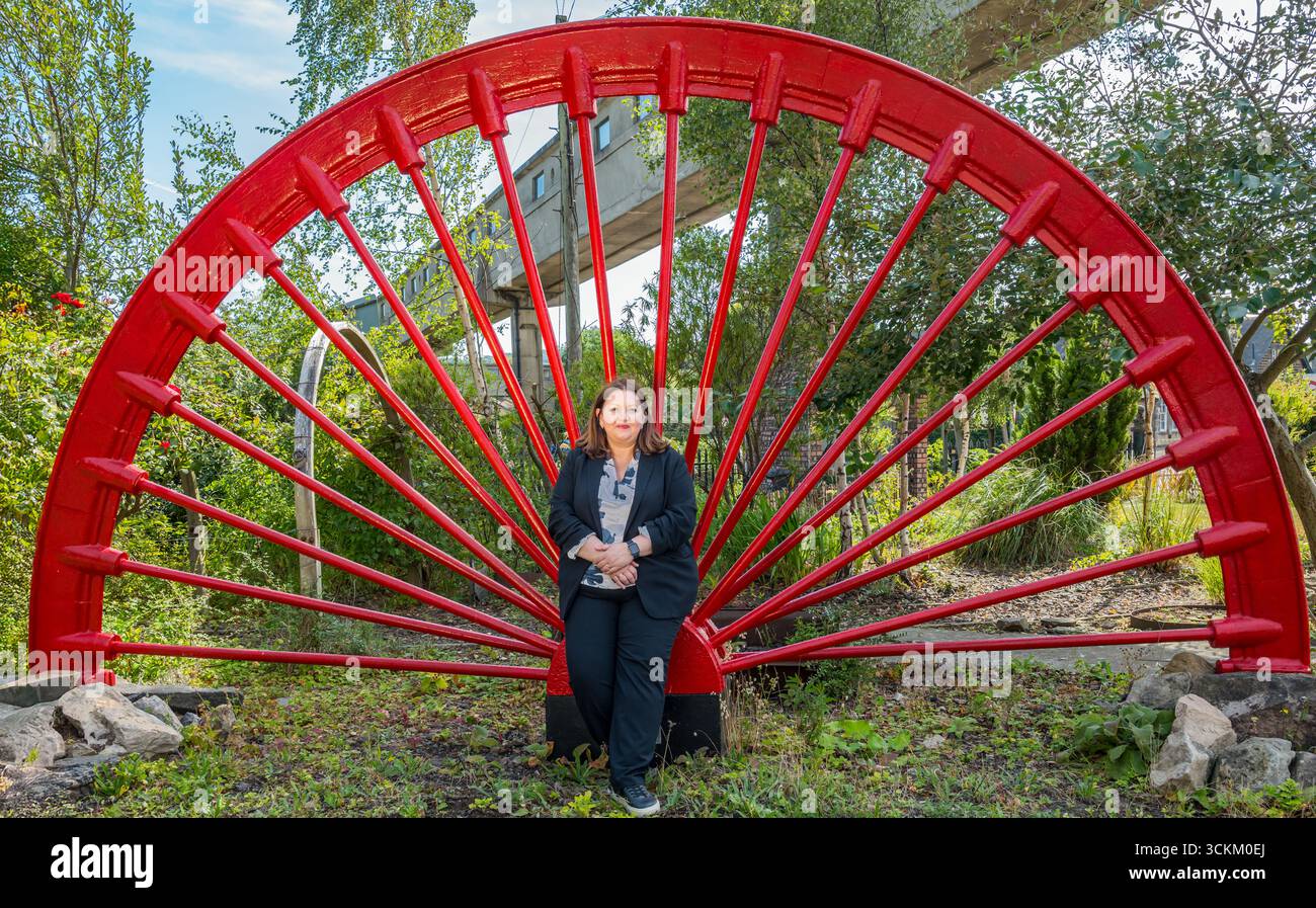Ritratto di Kirsty McNeill (deputato del lavoro scozzese) con ruota industriale, National Mining Museum, Newtongrange, Midlothian, Scozia, REGNO UNITO Foto Stock