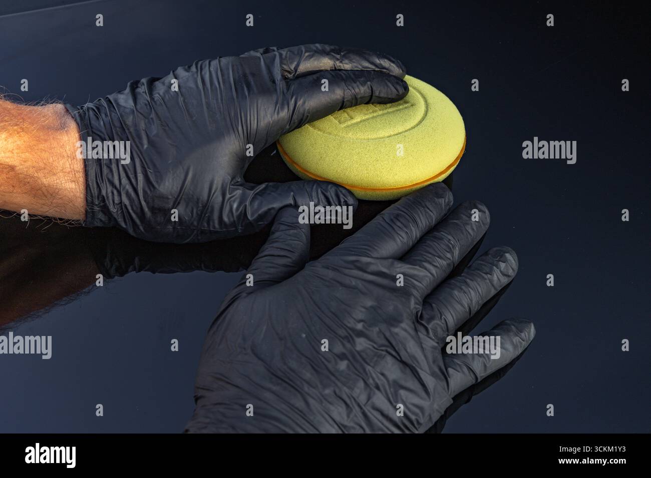 Un morbido tampone in spugna per lavare un'auto in mano a un uomo, con dettagli per lavare l'auto Foto Stock