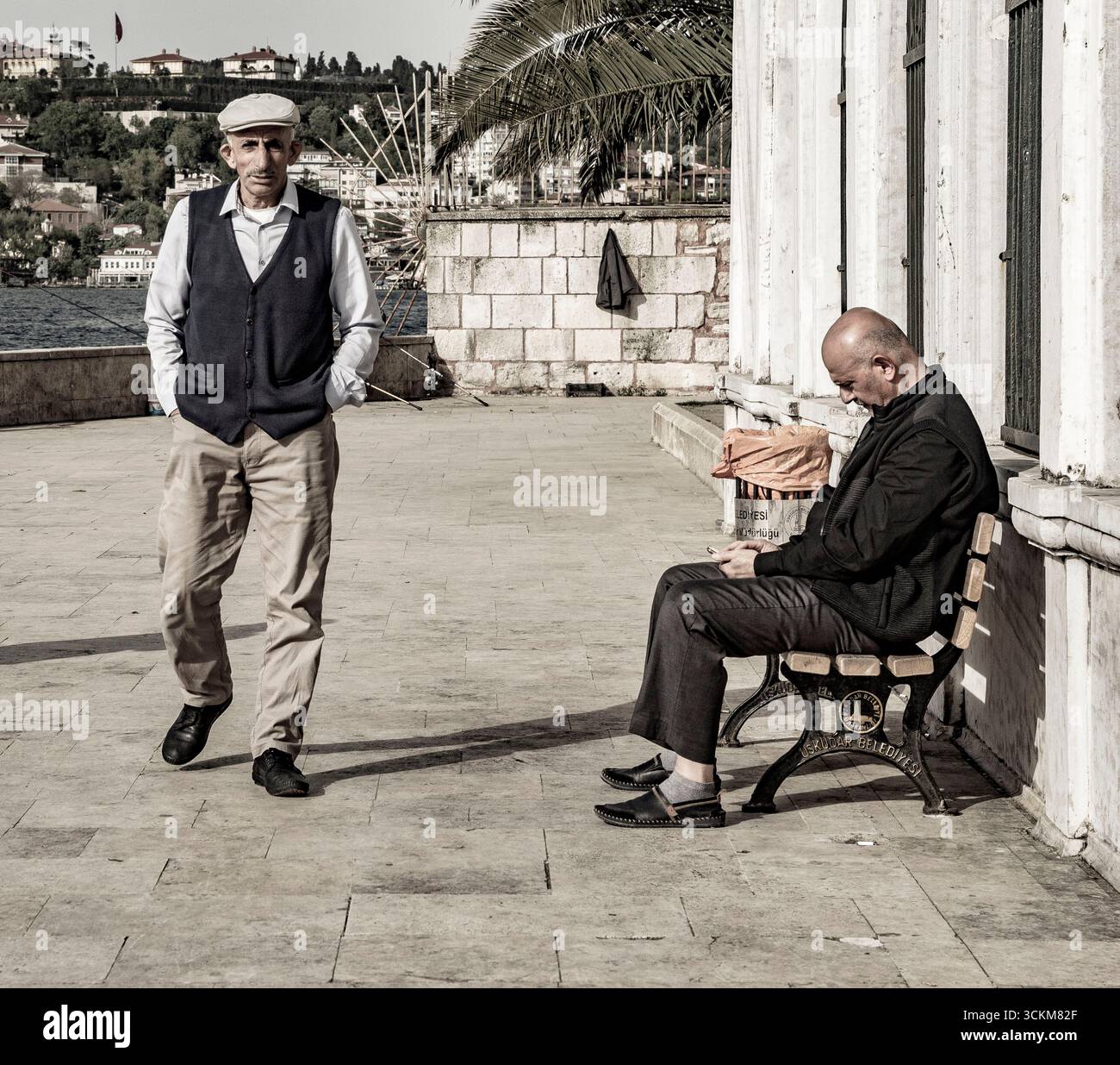 Scena di strada di due uomini turchi, uno che cammina e uno seduto Foto Stock
