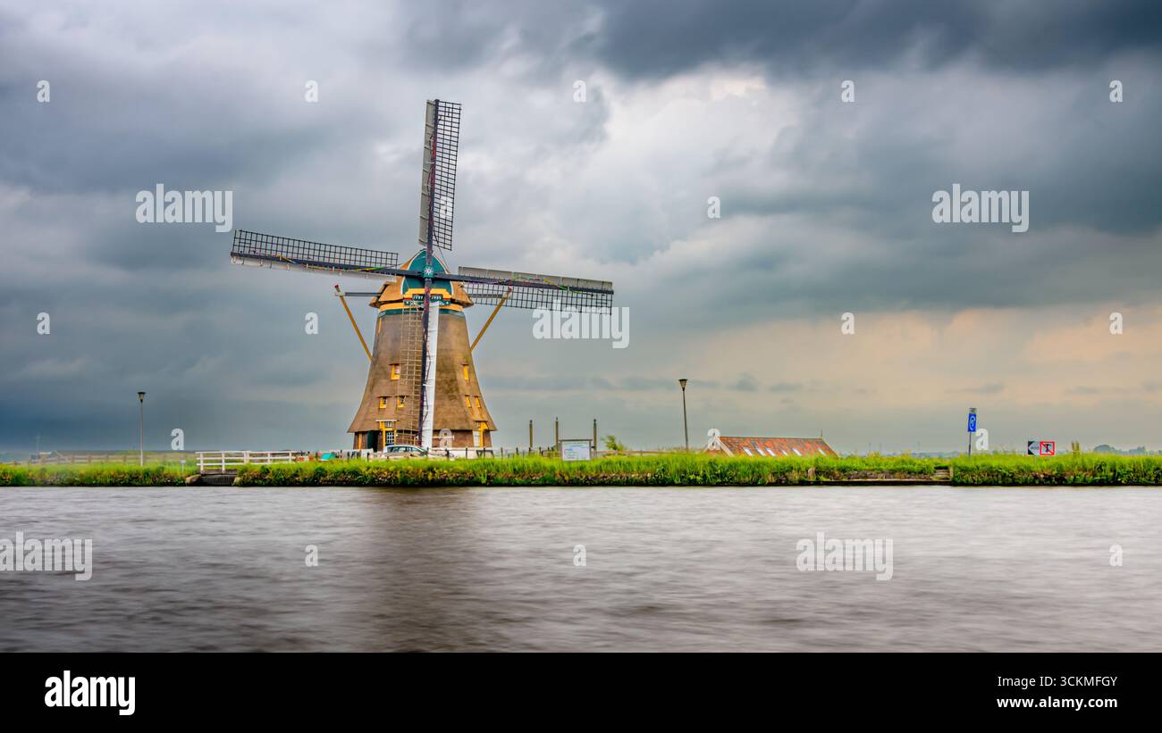Mulino Vrouwgeest lungo l'Heimanswetring ad Alphen aan den Rijn. Un paesaggio olandese in una giornata nuvolosa Foto Stock