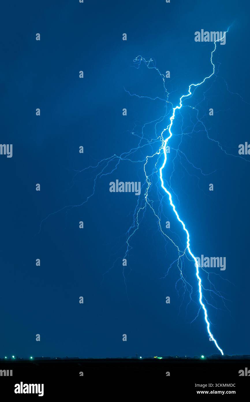Potente fulmine che illumina il cielo notturno con una vibrazione elettrica Foto Stock