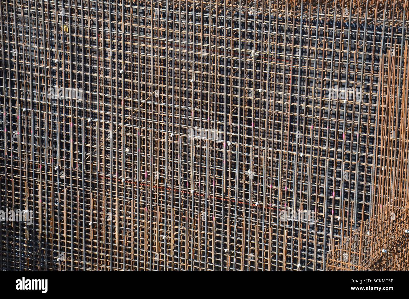 Primo piano di una struttura in acciaio con barre di rinforzo visibili. Dettaglio degli elementi strutturali in un cantiere, con materiali ingegneristici A. Foto Stock