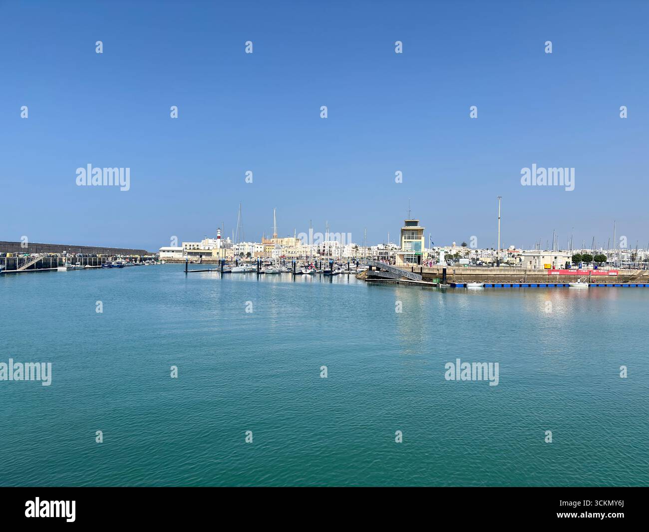 Porto di Rota, con barche da pesca, pontili, navi navali e paesaggi costieri nella baia di Cádiz sotto i limpidi cieli andaluschi. Spagna Foto Stock