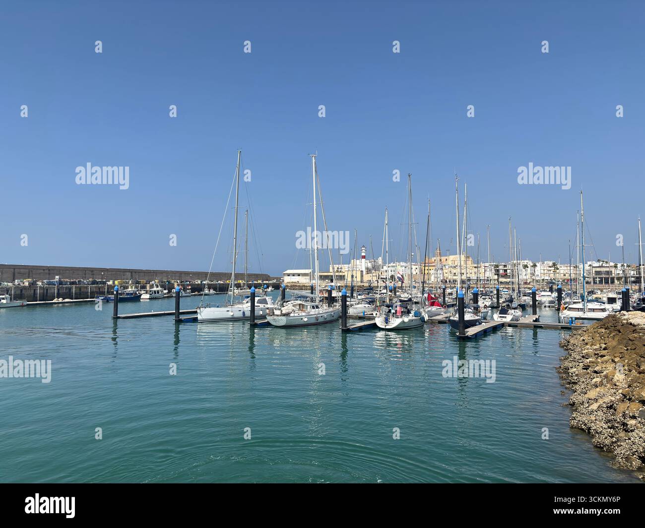 Porto di Rota, con barche da pesca, pontili, navi navali e paesaggi costieri nella baia di Cádiz sotto i limpidi cieli andaluschi. Spagna Foto Stock