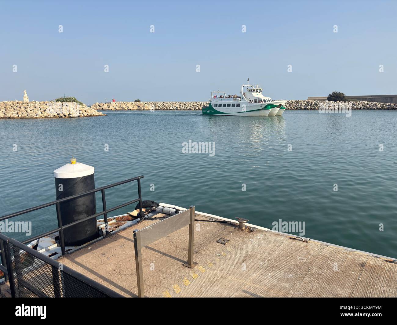 Porto di Rota, con barche da pesca, pontili, navi navali e paesaggi costieri nella baia di Cádiz sotto i limpidi cieli andaluschi. Spagna Foto Stock