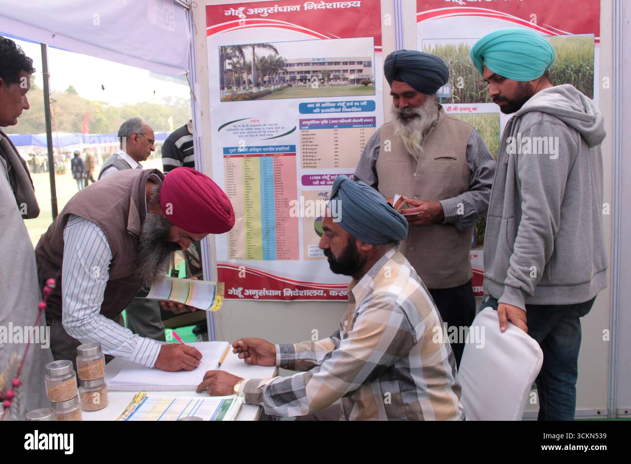 Gli agricoltori indiani cercano informazioni agricole in un'esposizione agricola a Delhi, India. Foto Stock