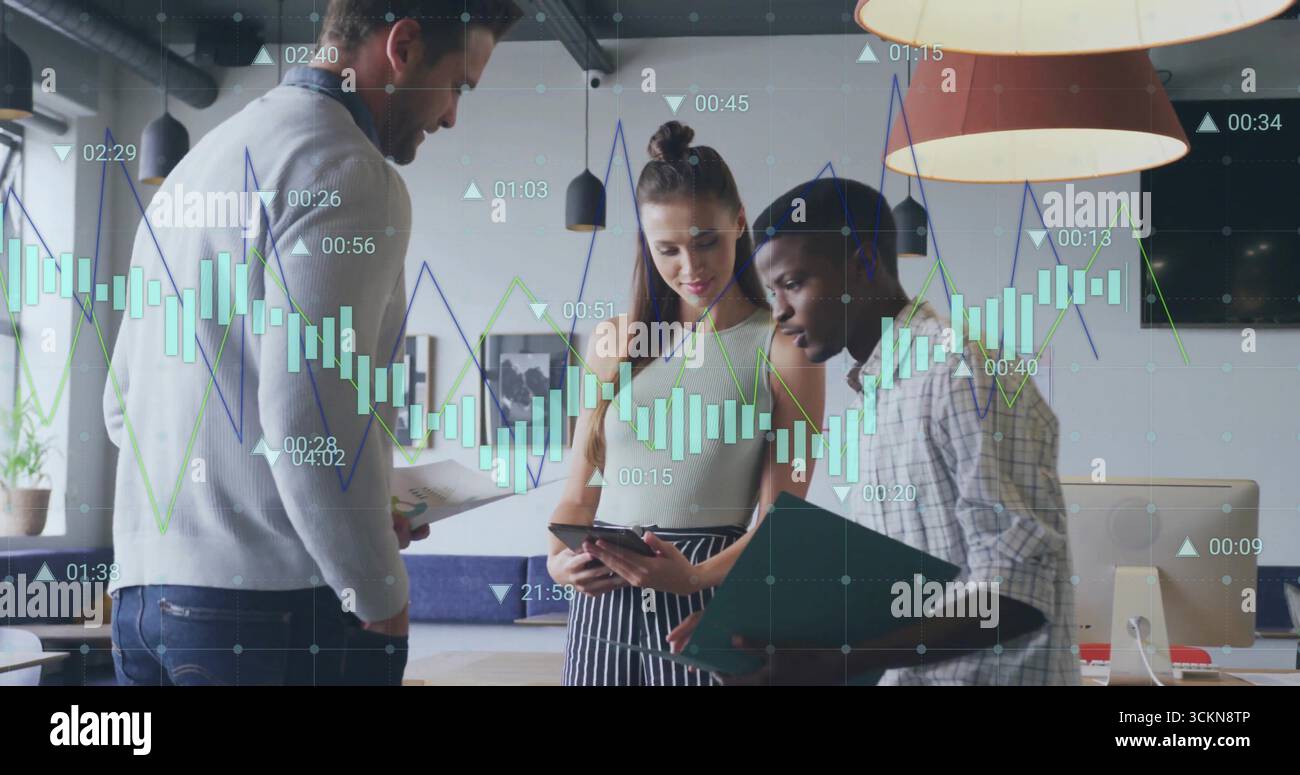 Collaborare con colleghi in abbigliamento casual, rivedendo le classifiche in ufficio, con tablet e appunti Foto Stock