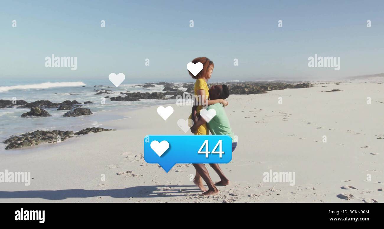 Coppia in abito giallo abbracciato sulla spiaggia, icone a forma di cuore galleggiante, bancone blu 44 Foto Stock
