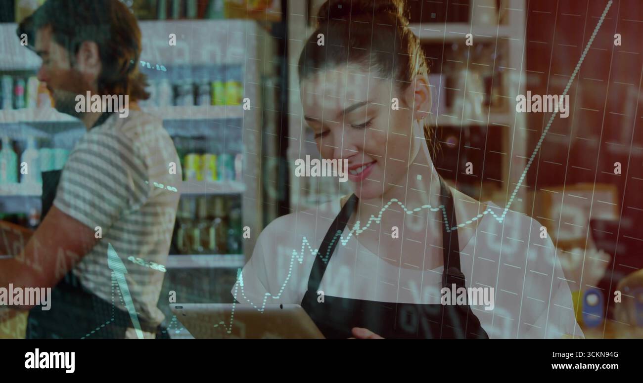 Picchiettare il dipendente di un tablet con grembiule nero al bar, con barattoli e lattine sugli scaffali Foto Stock