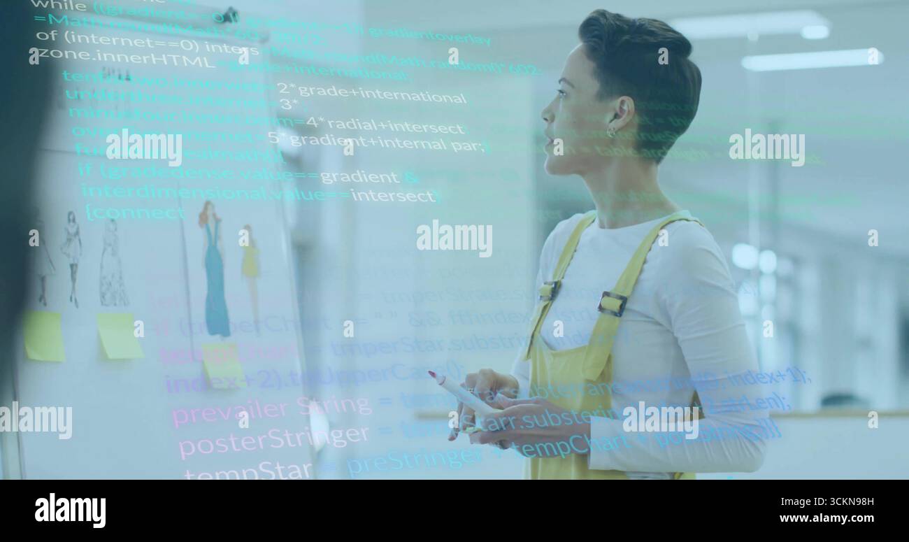 Esaminando gli schizzi e il codice della lavagna, donna in tuta con stilo e telefono in studio di progettazione Foto Stock