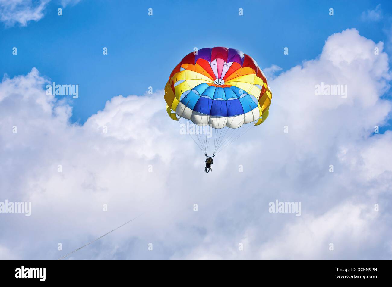 Parapendio con paracadute sullo sfondo di cielo nuvoloso blu. Foto Stock