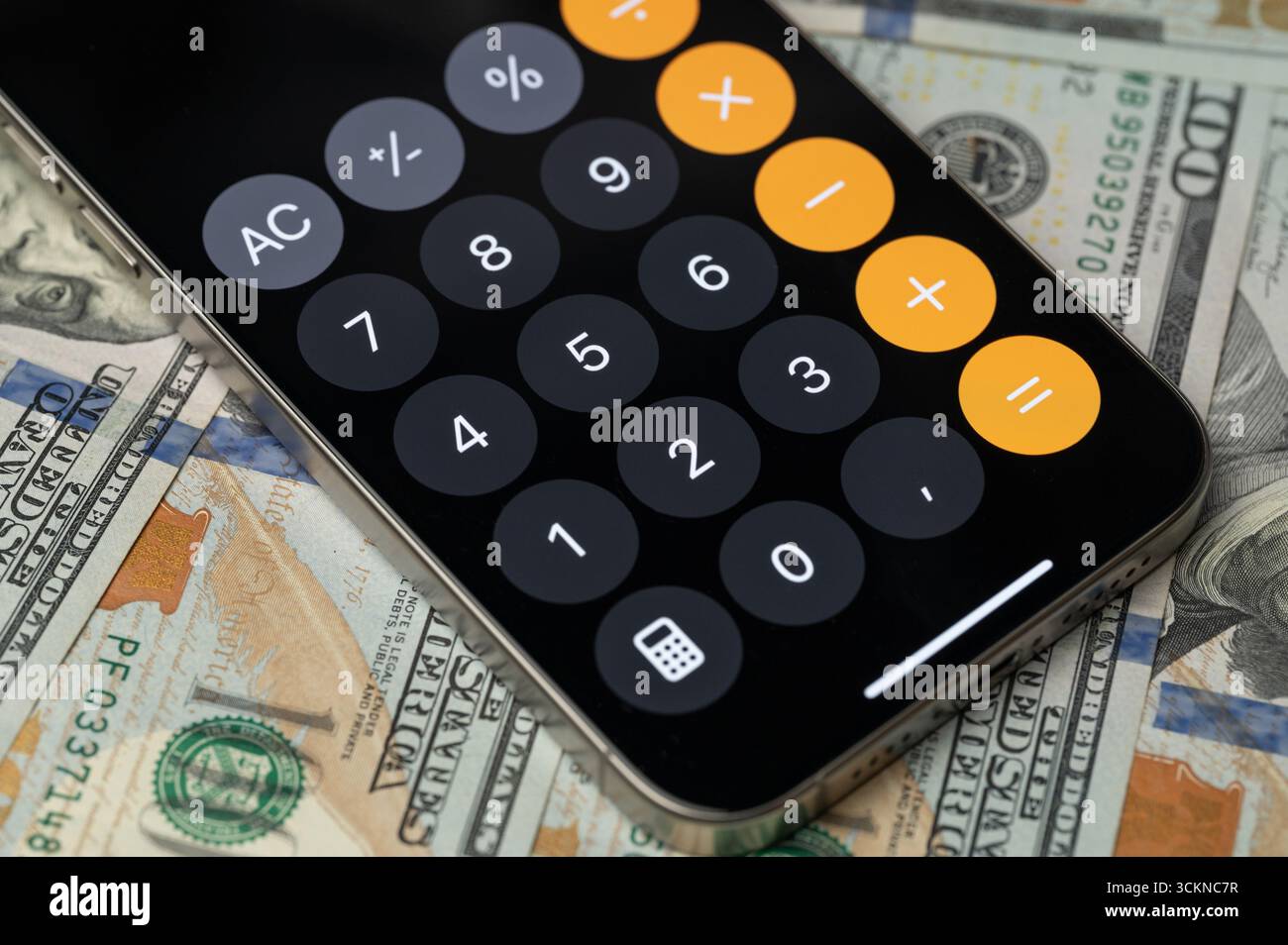 New York, USA - 12 settembre 2025: Menu della calcolatrice mobile sullo schermo dello smartphone con vista ravvicinata sullo sfondo del dollaro Foto Stock