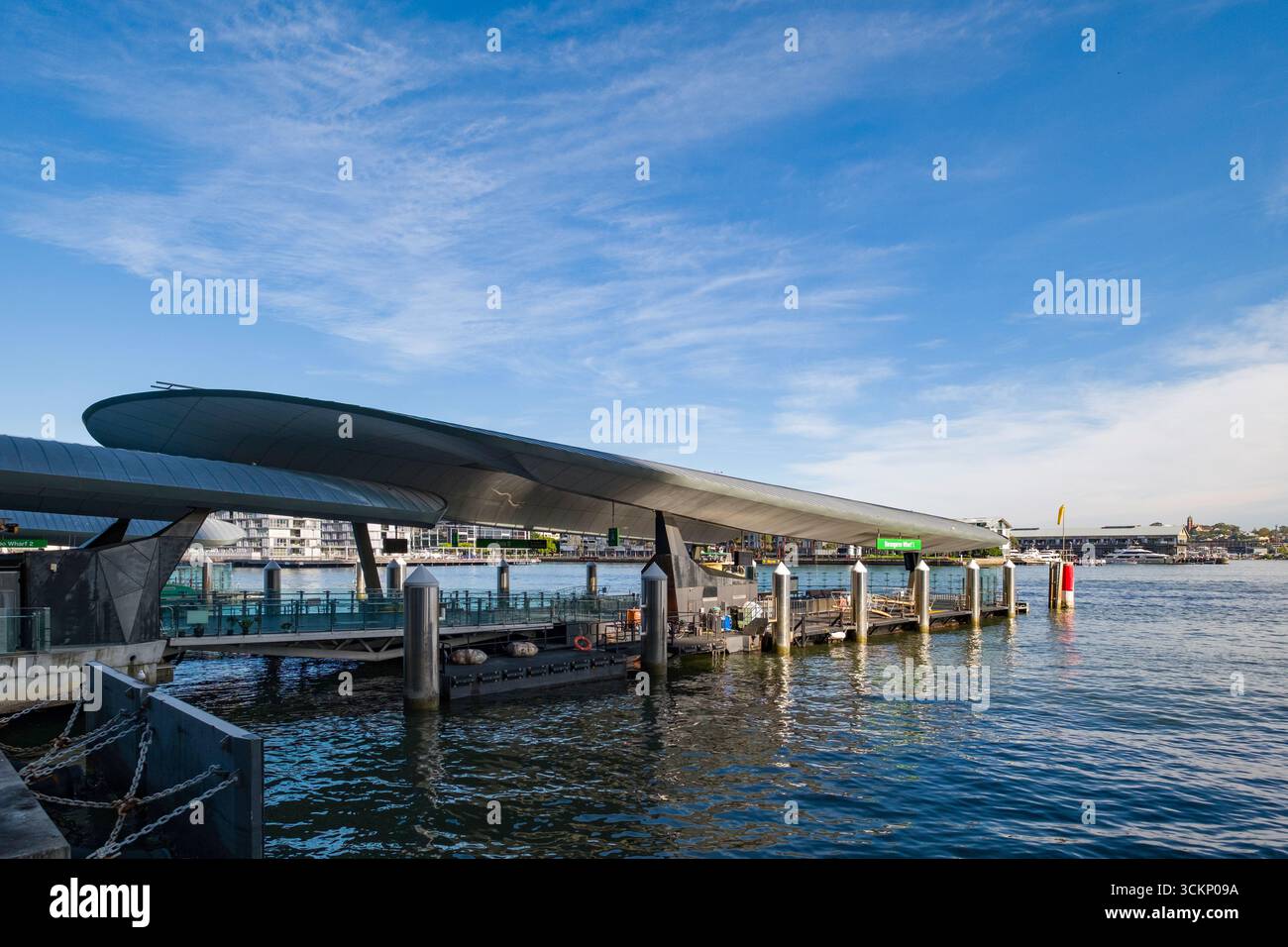 Barangaroo Wharf-1 terminal dei traghetti con architettura metallica situato in un tranquillo corso d'acqua sotto un cielo azzurro, Barangaroo, Sydney Foto Stock