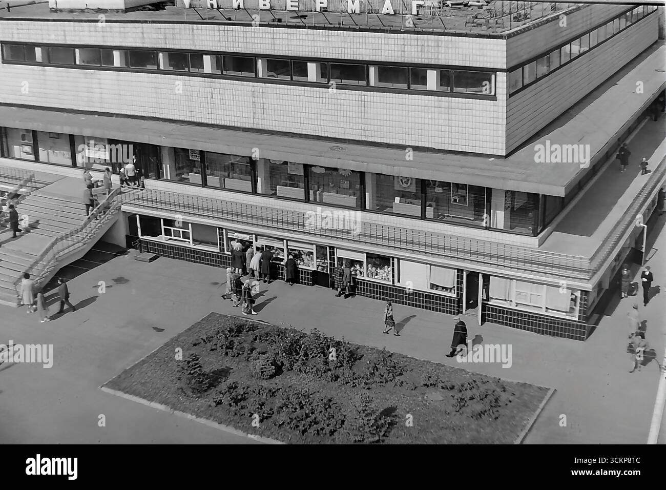 Vista panoramica del grande magazzino Yubileyniy (Jubilee) a Sloviansk, 1976. L'edificio, in stile modernista sovietico e situato in Piazza della Rivoluzione d'ottobre (ora Piazza Soborna), è mostrato come un centro del commercio urbano e della vita sociale. Gli scatti riflettono la vita quotidiana e l'architettura dell'era della stagnazione, simboleggiando la vita pacifica e ben tenuta a Donbas, dove il negozio centrale era un punto di attrazione per migliaia di cittadini Foto Stock