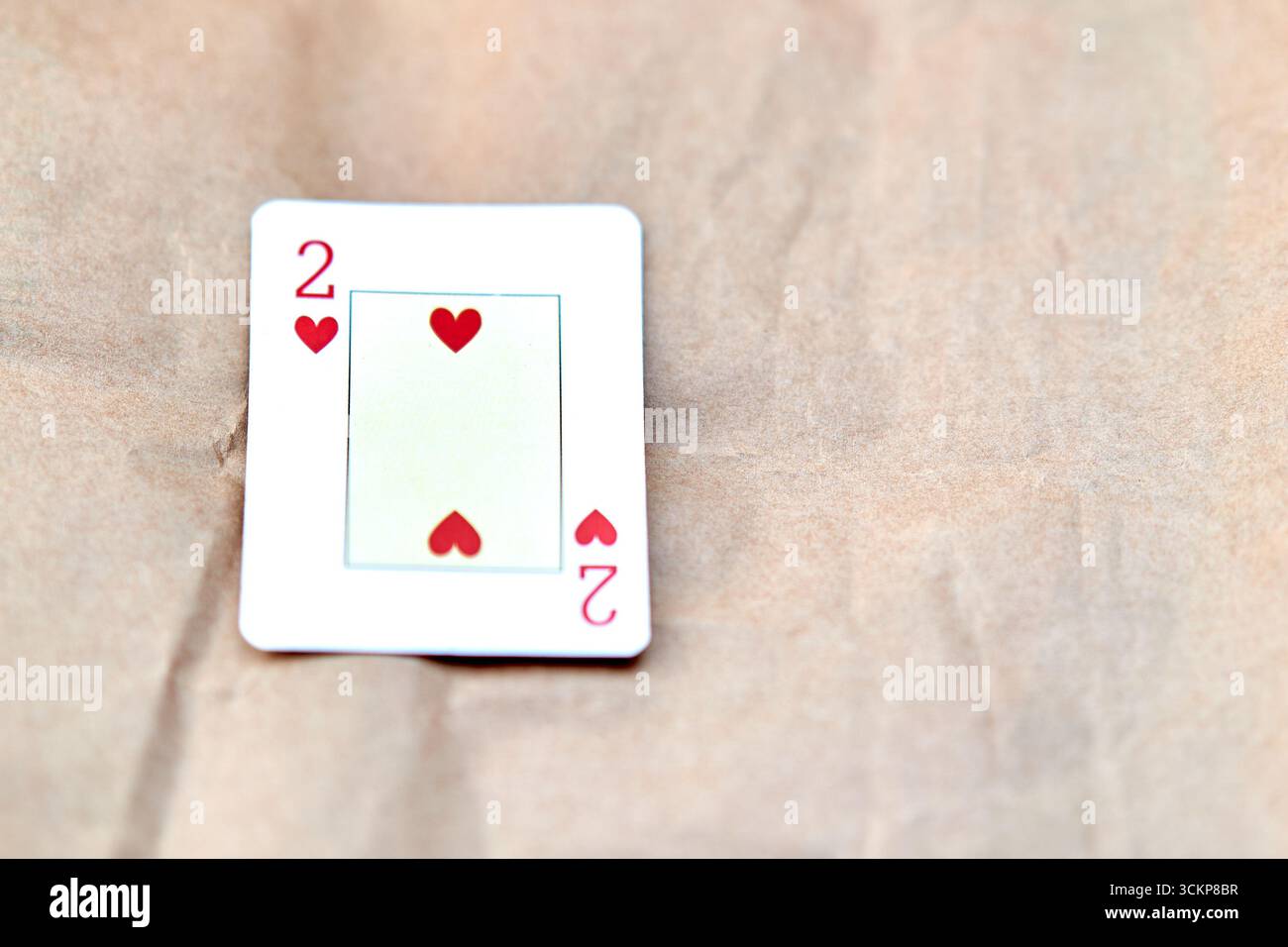 Due carte da poker Hearts su sfondo di cartone che rappresentano l'amore. Foto Stock