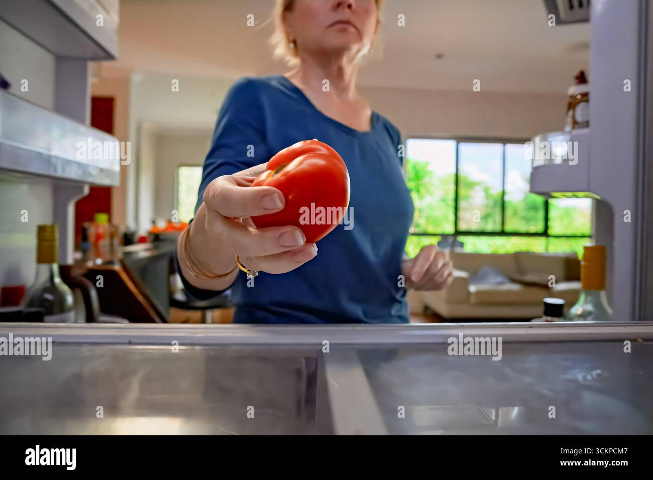 donna che porta il pomodoro fresco fuori dal frigorifero, dal punto di vista interno del frigorifero, cucina la spesa di tutti i giorni compiti domestici Foto Stock