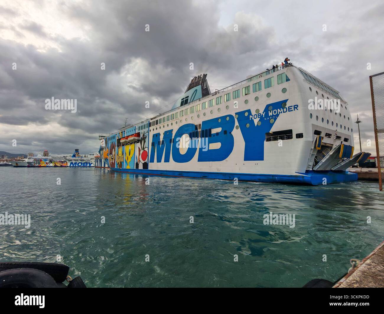 Genova, Italia - 13 settembre 2025: Il traghetto Moby Wonder è ormeggiato nel porto di Genova. La nave passeggeri e RoRo della compagnia di navigazione Moby si distingue per i suoi colorati dipinti a fumetti e collega le città portuali italiane nel Mediterraneo *** Die Autofähre Moby Wonder liegt im Hafen von Genua. DAS Passagier- und RoRo-Schiff der Reederei Moby fällt durch bunte Cartoon-Bemalungen auf und verbindet italienische Hafenstädte im Mittelmeer Foto Stock
