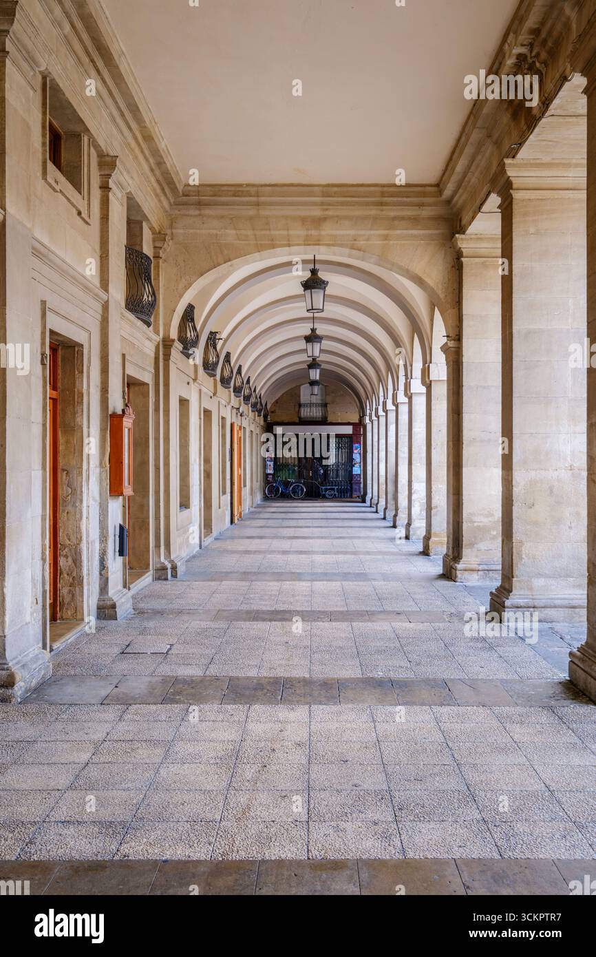 Storica galleria di pietra con colonnato ad arco e Lanterne tradizionali. Architettura classica, passerella coperta, centro storico europeo, prospettiva Foto Stock