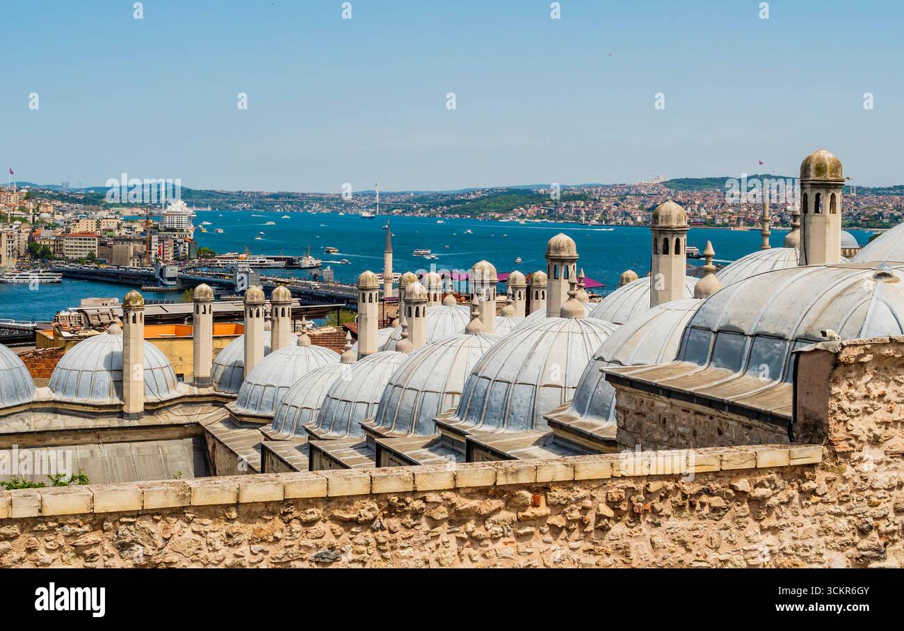 Impressionante vista del quartiere di Galata, dello stretto del Bosforo e del Corno d'Oro attraverso le cupole storiche della Moschea Suleymaniye, Istanbul, Turchia Foto Stock