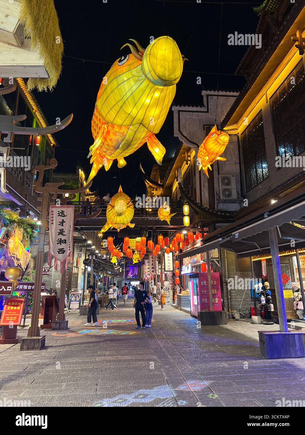 Luci serali che danzano su grondaie in stile antico, immergendoti nel fascino della città. Foto Stock