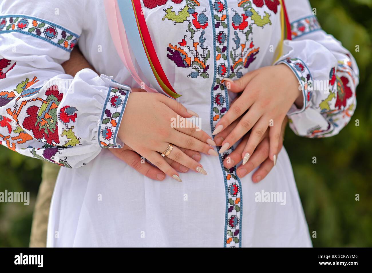 l'uomo ha abbracciato la vita della donna da dietro. una donna ricamata. Camicia ricamata Ucraina. primo piano di una mans mani che abbracciano una donna, mani di donna su m Foto Stock