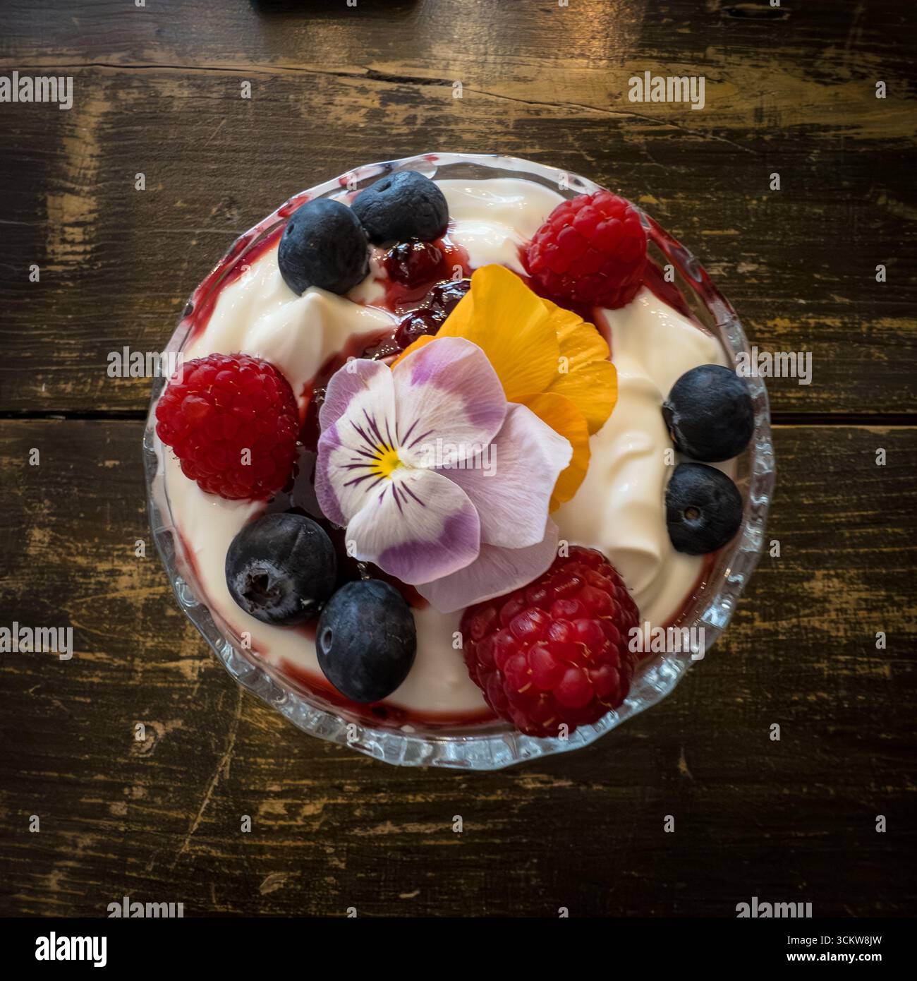 Colazione con frutta fresca con fiori commestibili, frutti di bosco e yogurt greco - Immagine stock catturata con smartphone