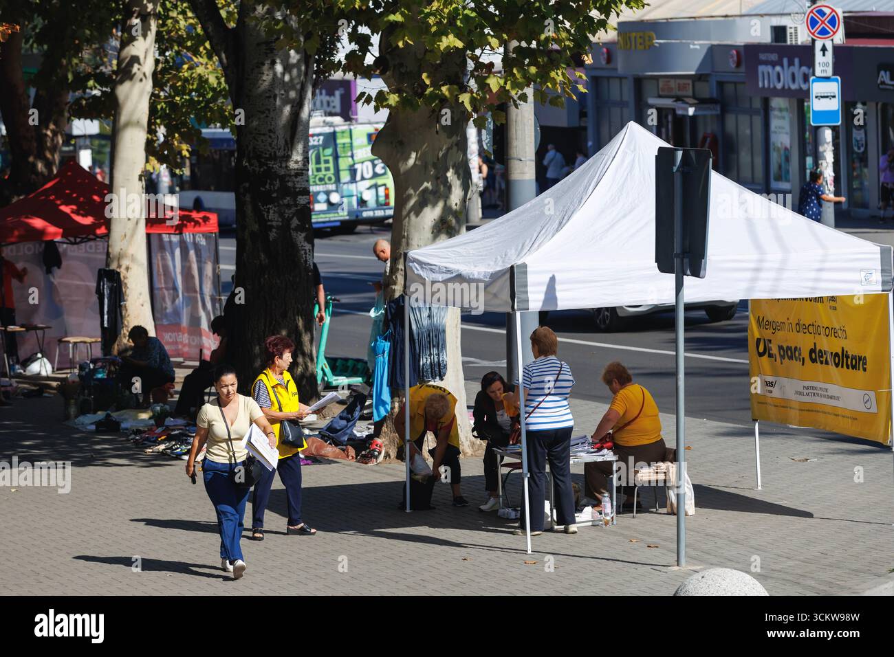 Tenda per campagna di strada con rappresentanti del partito che ingaggiano pedoni durante le elezioni in Moldavia. Foto Stock