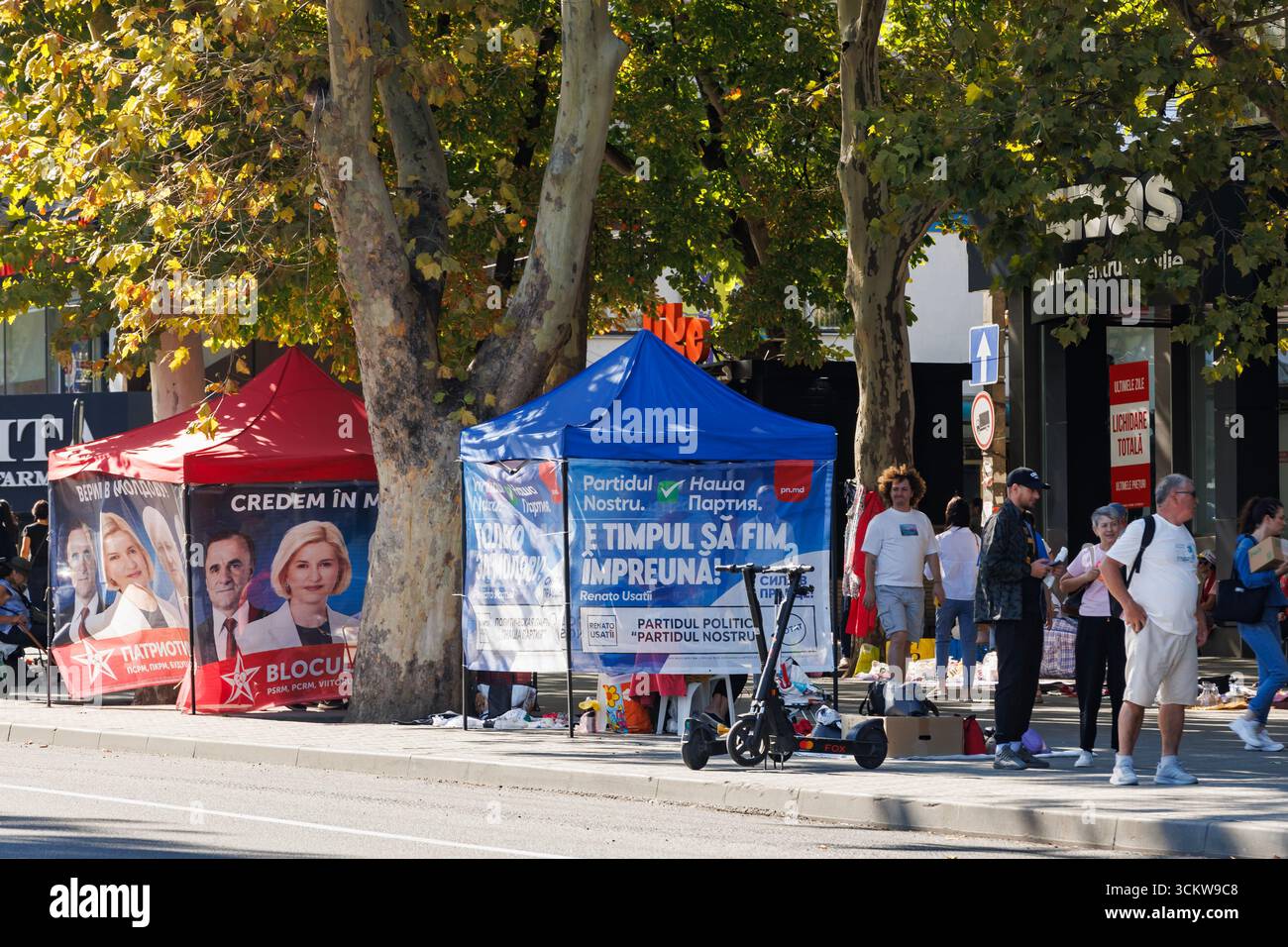 Vista sulla strada con cabine di promozione politica durante le elezioni. Le persone si riuniscono vicino a diverse tende politiche con simboli di partito durante il campo elettorale Foto Stock