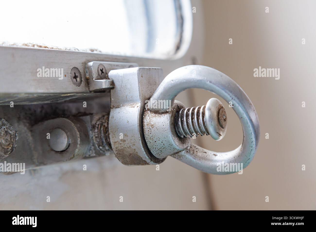 Il meccanismo di chiusura dell'oblò della nave sotto forma di un morsetto su un perno filettato e di una maniglia a vite. Foto Stock