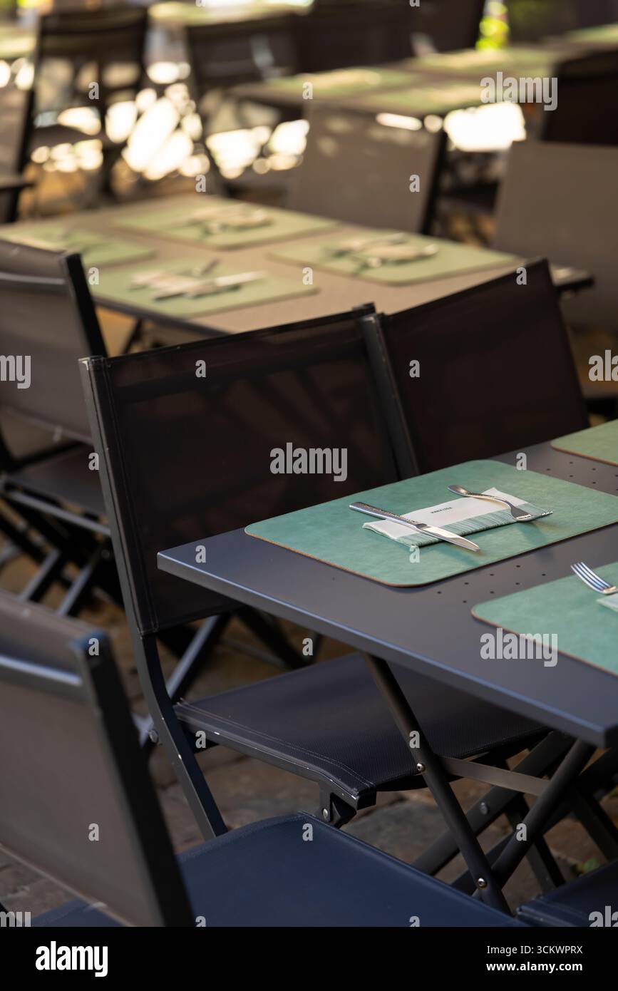 Tavoli e sedie vuoti in un ristorante all'aperto, pronti per l'arrivo dei clienti e per gustare un pasto Foto Stock