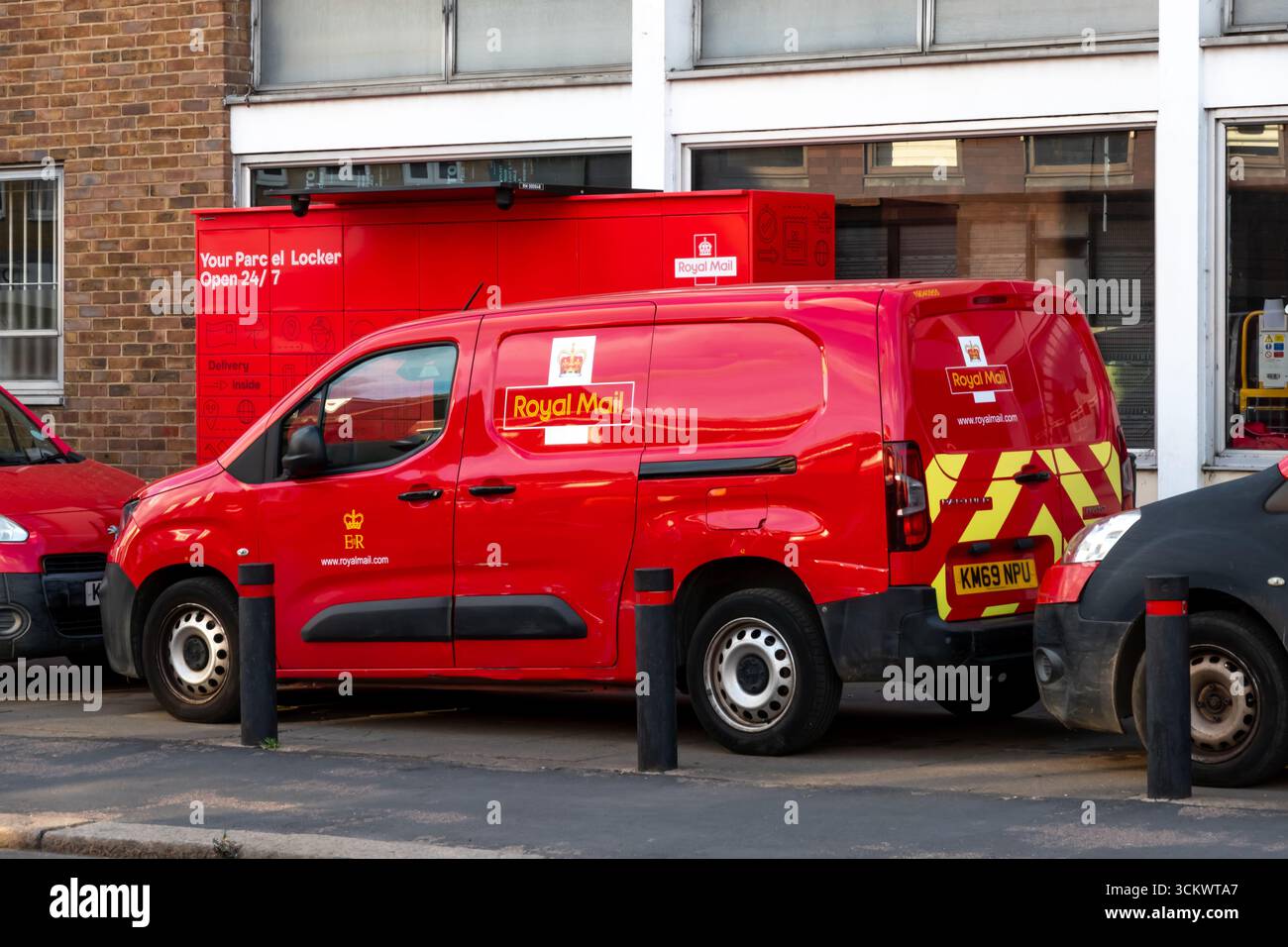 Un furgone rosso per la consegna della Royal mail è parcheggiato davanti a un armadietto dei pacchi a Bishops Stortford, Hertfordshire, Inghilterra. Sul furgone viene visualizzato il logo Royal mail Foto Stock