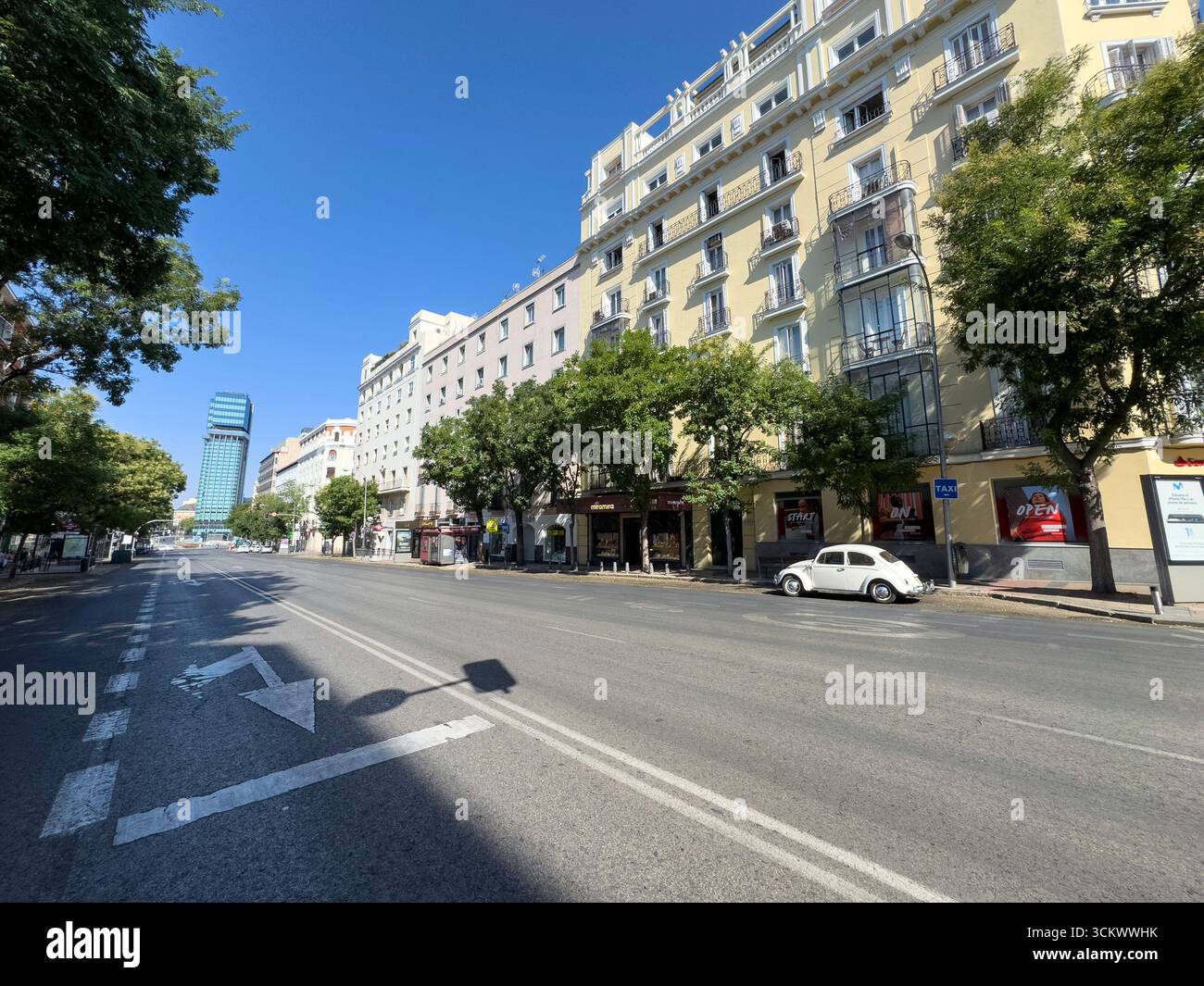 Calle Goya, barrio Salamanca, con le Torri Colon alle spalle. Un Beetle Volkswagen bianco vintage è parcheggiato, Madrid, Spagna - Immagine stock catturata con smartphone