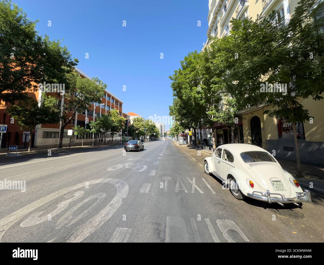 Calle Goya, barrio Salamanca, con le Torri Colon alle spalle. Un Beetle Volkswagen bianco vintage è parcheggiato, Madrid, Spagna - Immagine stock catturata con smartphone