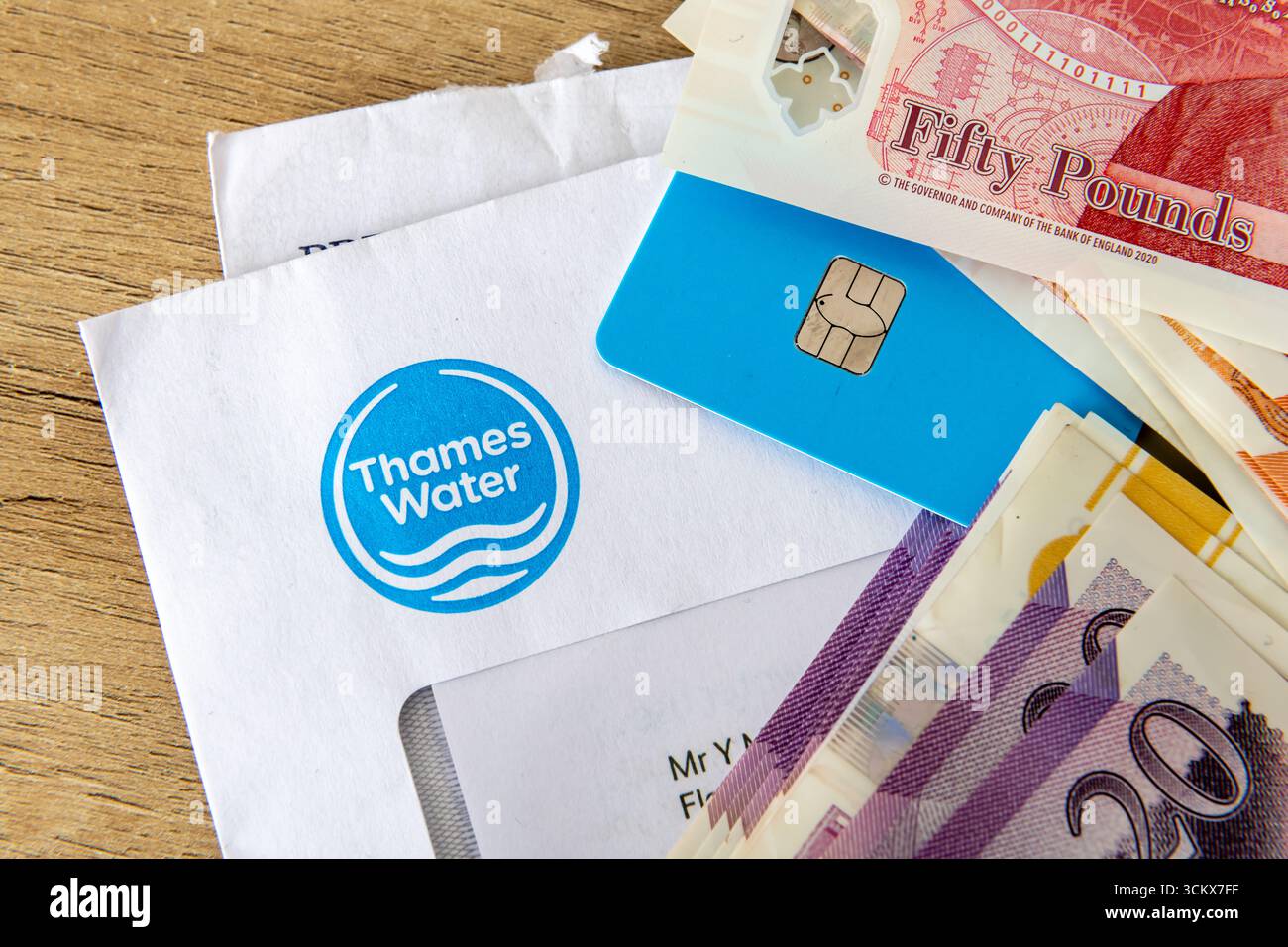 Londra. Regno Unito - 31 agosto 2025. Un primo piano macro di una bolletta Thames Water in cima a un'altra bolletta con una carta di credito e una pila di Sterlina Foto Stock